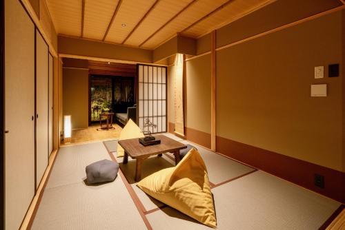 une chambre japonaise avec une table et une chaise dans l'établissement Hanatsume Machiya House, à Kanazawa