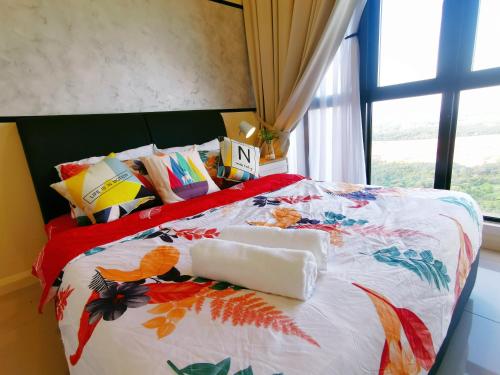 una cama con una colcha colorida y una ventana en Legoland-HappyRainbow Suite at D'Pristine-8pax with Lakeview en Nusajaya
