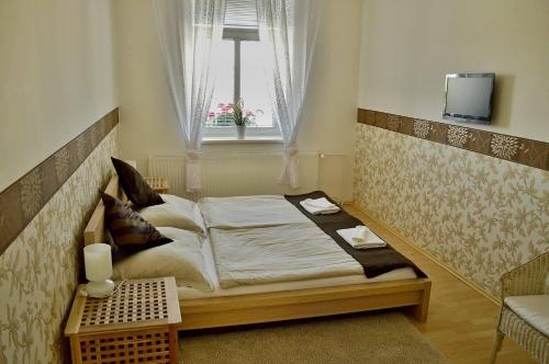 a bedroom with a large bed with a window at Hotel Florian in Slavkov u Brna