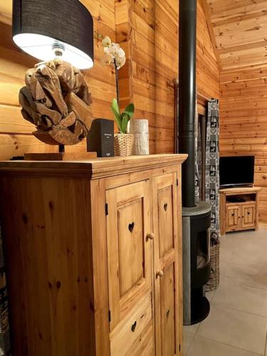 Cette chambre dispose d'une cabine en bois avec un poêle à bois. dans l'établissement Chalet Le Familial - SPA & SAUNA - Serviettes - Peignoirs - Lits faits - Ménage inclus, à Rochesson