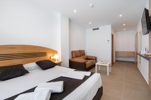 ein Schlafzimmer mit einem großen Bett und einem Stuhl in der Unterkunft Plaza de la Luz Cádiz in Cádiz