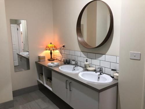 Un baño con dos lavabos y un espejo grande. en Heritage Cottage Daylesford, en Daylesford