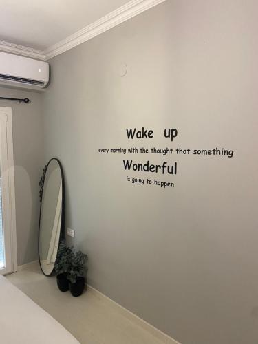 a bathroom with a mirror and a wall with a sign on it at 415 Guest House in Xanthi