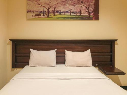 Un pat sau paturi într-o cameră la Hotel D'Mario Palopo
