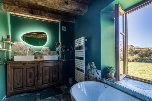 ein Bad mit einer Badewanne und einem Fenster in der Unterkunft La grange de l'Adour in Campan