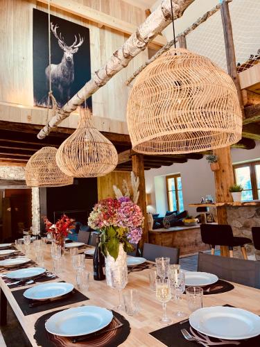 d'une salle à manger avec une table, des chaises et des lustres. dans l'établissement La grange de l'Adour - Trassouet, à Campan