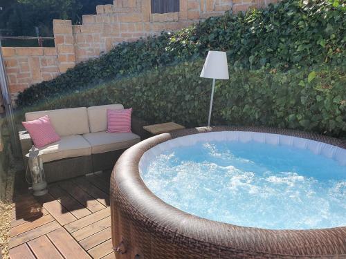 a jacuzzi tub in a garden with a couch at Hüttenglück in Innernzell