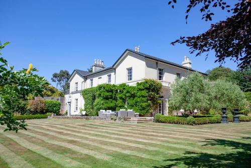 uma grande casa branca com um grande quintal em St Anne's Manor - Luxury Villa with Hot Tub em Torquay