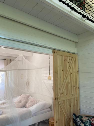 a bedroom with a bed and a wooden door at Bajkowy domek Villa Rosa na Kaszubach in Grzybowo