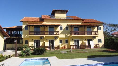 a house with a swimming pool in front of it at Pousada das Garças in Saquarema