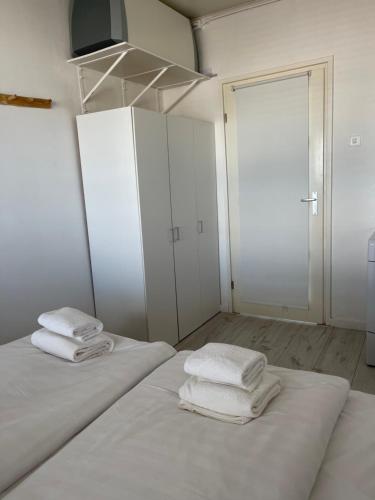 duas camas num quarto branco com toalhas em Top View em Zandvoort