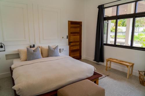 a bedroom with a large bed and a window at THALEMAAN POOL VILLA in Koh Samui 