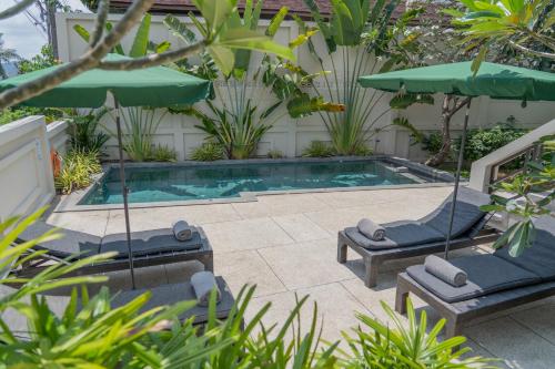 a swimming pool with two lounge chairs and an umbrella at THALEMAAN POOL VILLA in Koh Samui 