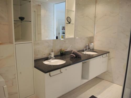 a bathroom with two sinks and a large mirror at Alice Holiday Apartment in Locarno