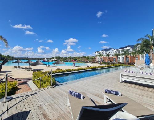 - une piscine dans un complexe avec des chaises et des parasols dans l'établissement MINT Resorts The Blyde, à Pretoria