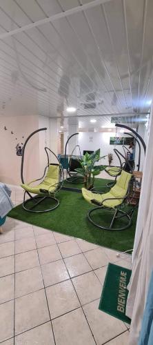 um quarto com cadeiras e um tapete verde em Le soleil couchant em Le Tampon