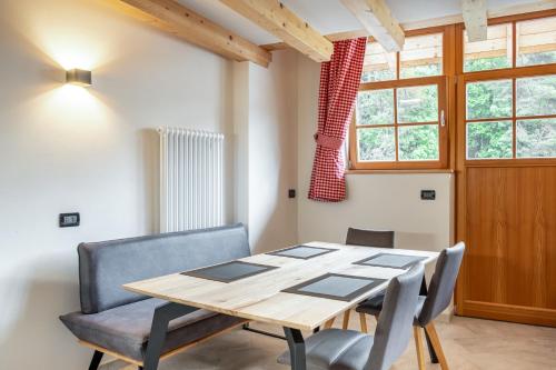 une salle à manger avec une table et des chaises en bois dans l'établissement Apart Dolomites, à Castello-Molina di Fiemme