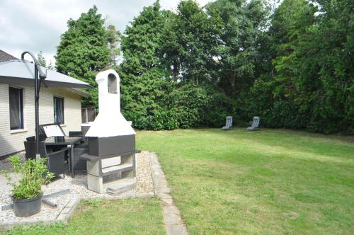 a backyard with a grill in a yard at Haus Kenzo 65348 in Moormerland