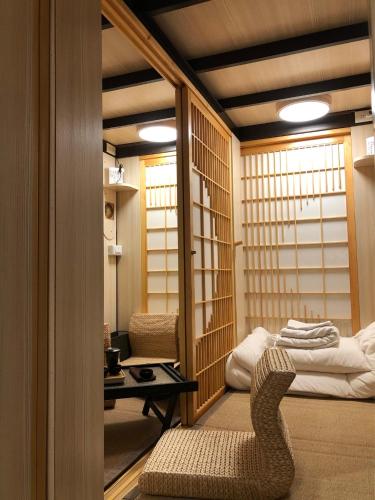 a room with a chair and a bed in it at 台甕茶室青年旅館 Tai-Wong Tatami Room Hostel in Tainan