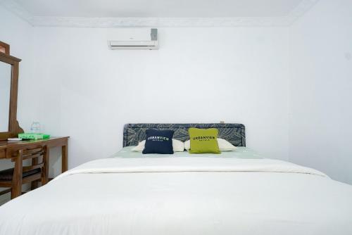 a white bed with two pillows on top of it at Urbanview Hotel Syariah Ratu Kuring Gisting by RedDoorz in Banjarnegeri