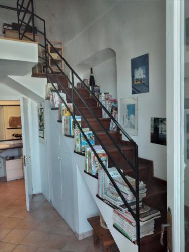 una escalera de caracol llena de libros en una casa en Casa di Grazia, en Isquia
