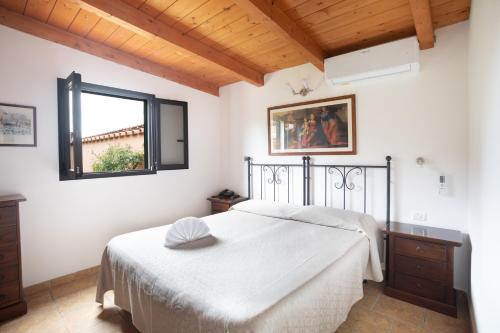 a bedroom with a white bed and a window at Country Hotel Residence Da Pilade in Capoliveri