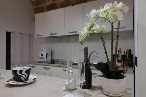 a kitchen counter with a vase with white flowers in it at Relax Santa Cecilia in Gravina in Puglia