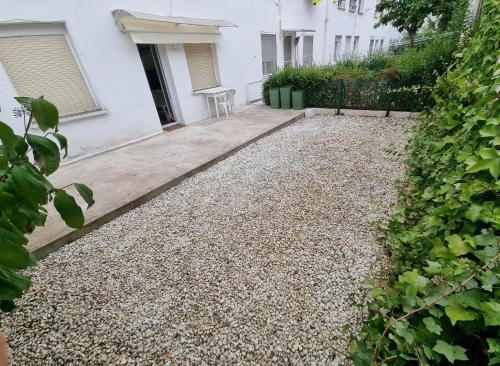 維多利亞的住宿－Vive Vitoria Apartamento con jardín，一个带碎石车道和白色房子的花园