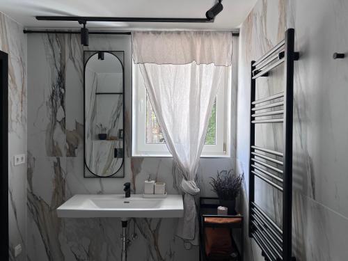 uma casa de banho com um lavatório, um espelho e uma janela em Cozy beach house Jurmala III em Jūrmala