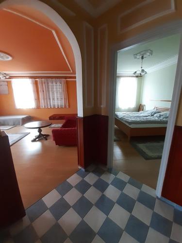 Habitación con cama y suelo de tablero de ajedrez en Gábor Pál 1 Apartman 1 szoba, en Dunaföldvár