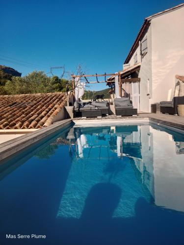 une piscine avec de l'eau bleue devant une maison dans l'établissement Mas Serre Plume, à Saint-Bauzille-de-Montmel