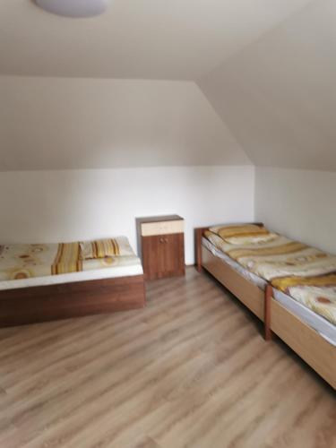 2 camas en una habitación con suelo de madera en Noclegi Piotrków Tryb, en Piotrków Trybunalski