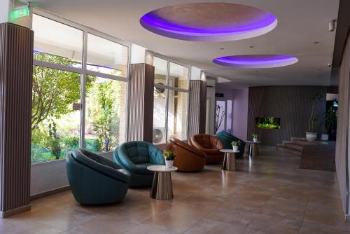ジュピテルにあるHotel Opalのソファ、椅子、紫色の照明が備わるロビー