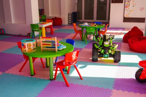 a classroom with tables and chairs and a toy car at Hotel Opal in Jupiter