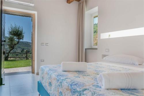 sypialnia z łóżkiem i dużym oknem w obiekcie Country House L'antica pietra w mieście Perdifumo