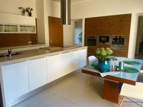 cocina grande con armarios blancos y mesa en Willa przy lesie, en Wronki