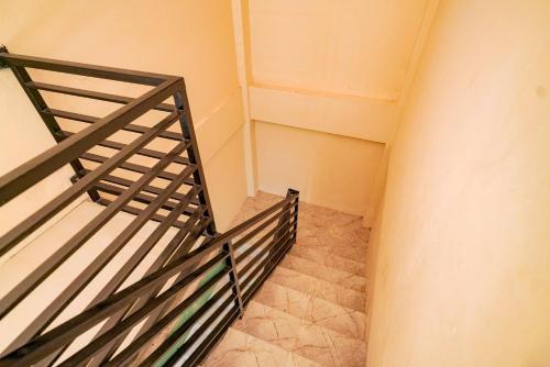 a stairway with a railing in a room at Urbanview Hotel St Faustina Lampung by RedDoorz in Kedaton