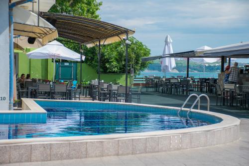 a pool at a hotel with tables and chairs at Paraiso Theopolis - All Inclusive in Obzor