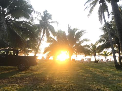 a truck parked on a beach with palm trees at Koh Yao Yai Sea Breeze House เกาะยาวใหญ่ซีบรีซเฮ้าส์ in Ko Yao Yai