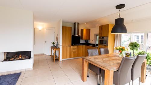 a kitchen and dining room with a table and a fireplace at Hof van Salland Hellendoorn in Hellendoorn