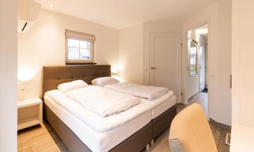 a bedroom with a large bed with white sheets at Hof van Salland Hellendoorn in Hellendoorn