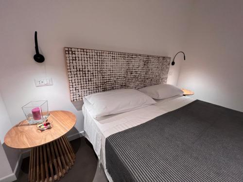 a bedroom with a bed with a wooden headboard and a table at Villa Chiara Taormina in Taormina