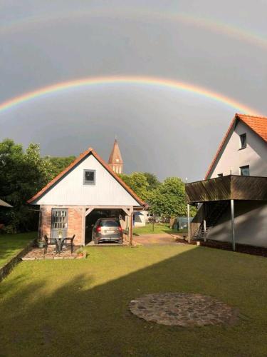 a rainbow in the sky over a house at Ferienwohnung am Storchnest in Kenz