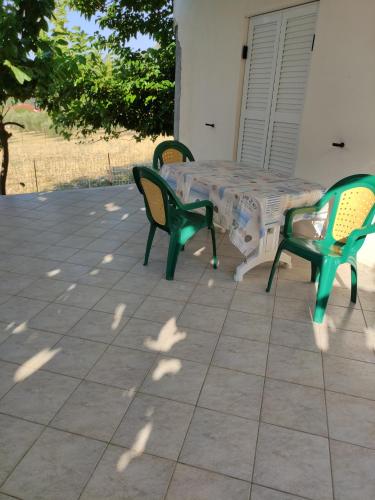 une table et des chaises assises sur une terrasse dans l'établissement Paganatos Place, à Sívros
