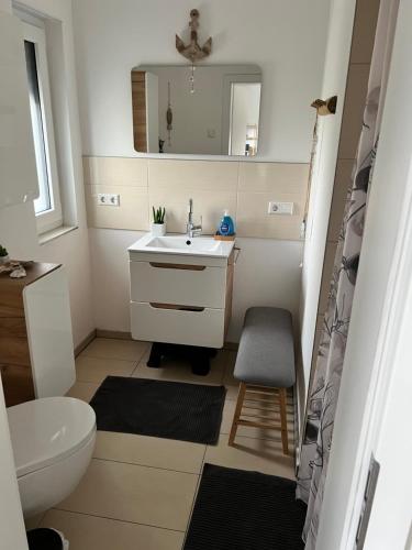 a bathroom with a sink and a toilet and a mirror at BeeHome Euskirchen in Euskirchen