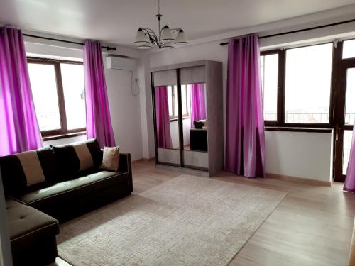 a living room with purple curtains and a couch at Diplomat 3 in Bishkek