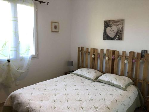 um quarto com uma cama e uma cabeceira em madeira em Le Relais du Gapeau em Solliès-Toucas