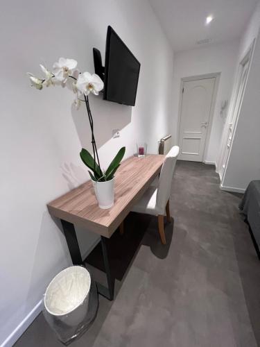 a dining room table with a tv and flowers on it at Villa Chiara Taormina in Taormina