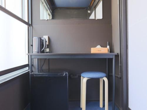 a desk with a blue stool next to a window at Setouchi Mangetsuso in Takamatsu