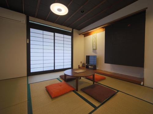 a room with a table and a projection screen at Setouchi Mangetsuso in Takamatsu
